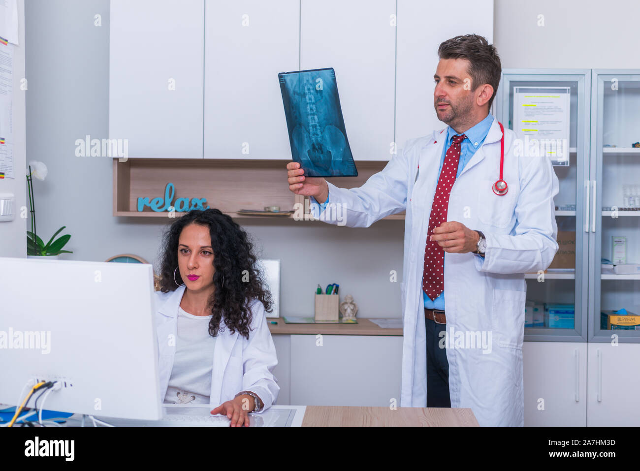 Männlicher Arzt in seiner Mitte 40 die Lesung ein Röntgenbild (Radiographie) von einem Patienten hip Region (COXA) beim Stehen in einem Krankenhaus Radiologie - Abteilung Stockfoto