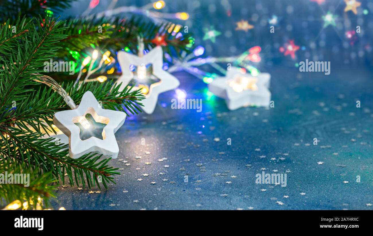 Festliche unscharf strahlende Weihnachten Hintergrund mit grünen Fir Tree Branch, Lichtgirlanden und Dekorationen Stockfoto
