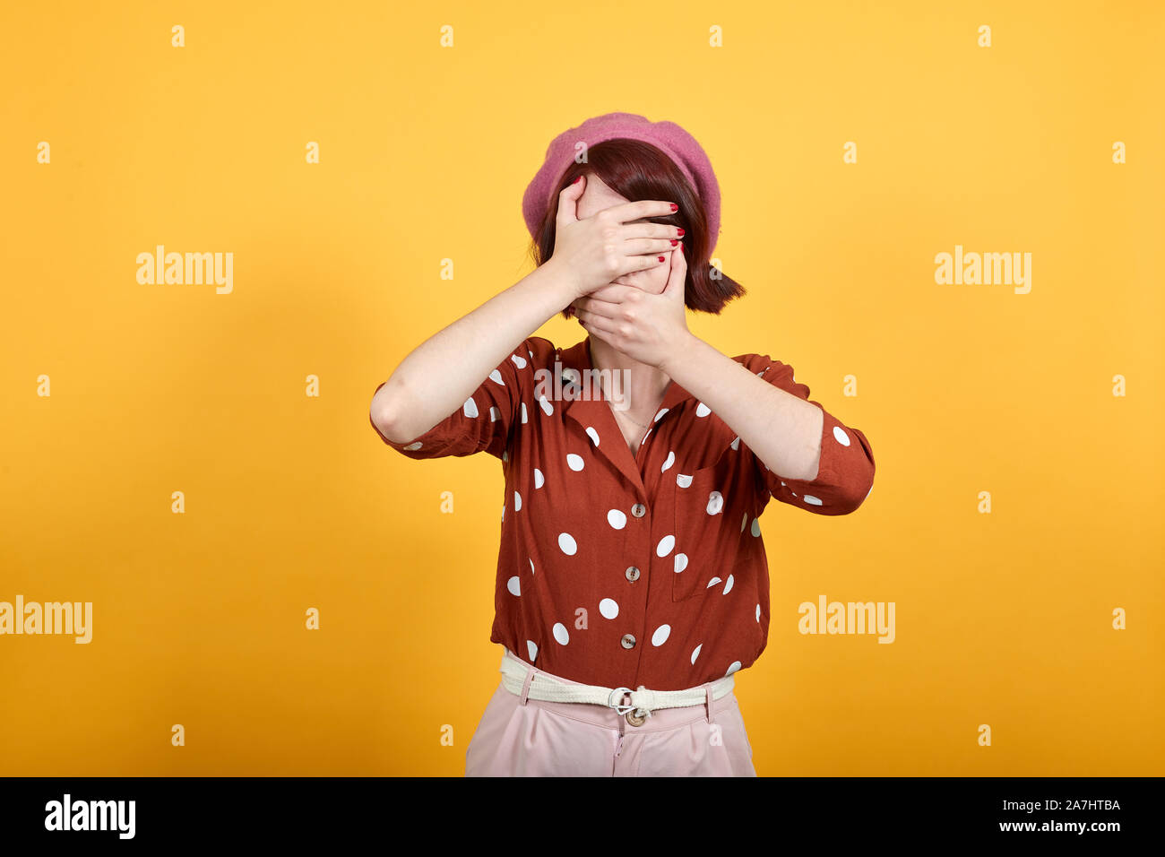 Junge Frau mit Augen und Mund mit den Händen, überrascht, schockiert Stockfoto