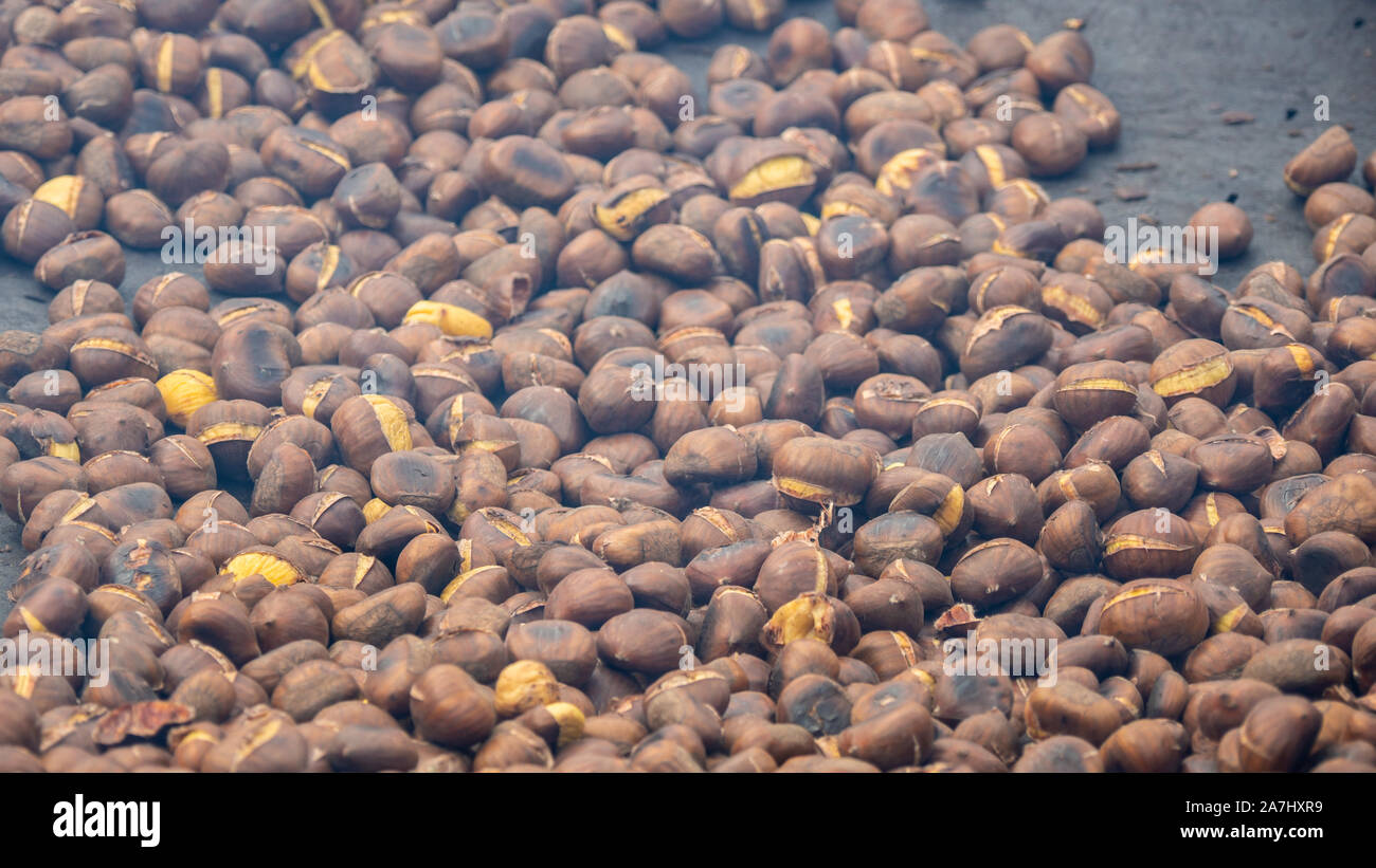 Kochen eine große Menge von Kastanien auf einem brazier. Herbst Jahreszeit. Kastanienfest Stockfoto