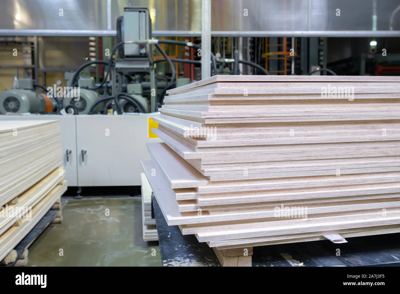 Gestapelte Sperrholz und Holzbrett Produkte gegen De-fokussierte verschwommen Stück industrial warehouse Storage am Produktionsstandort. Kopieren Sie Platz. Selektive f Stockfoto