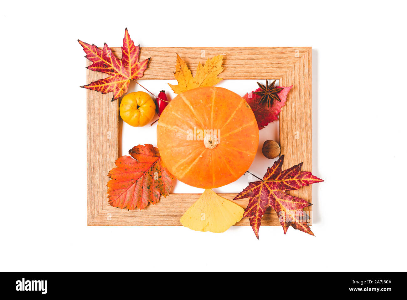 Bilderrahmen mit Herbstlaub, Quitte und orange Kürbis. Kreative Thanksgiving oder Halloween Konzept. Flach Stockfoto