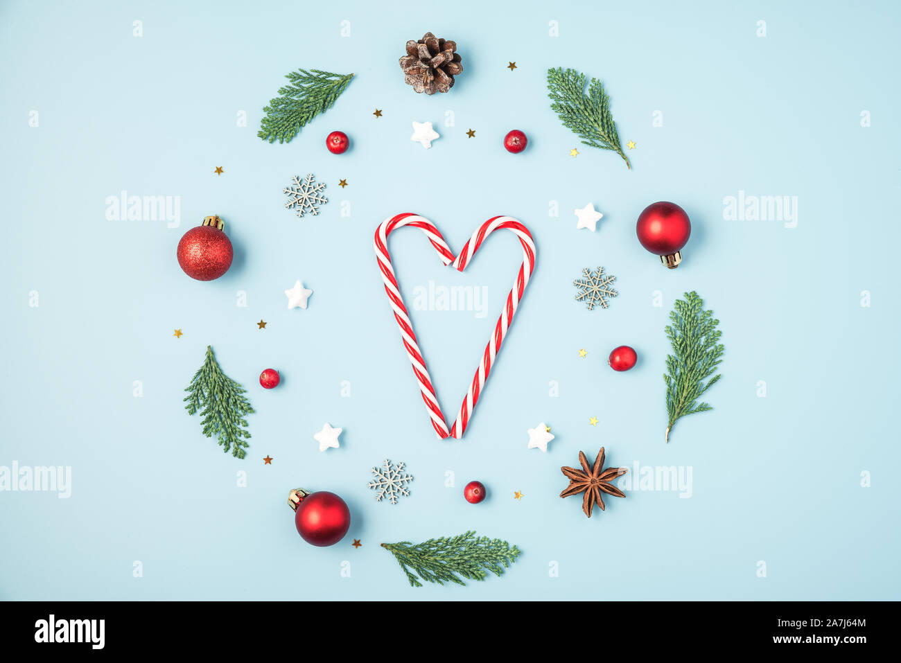 Weihnachten Komposition. Weihnachten Kranz aus Tanne Baum verzweigt, Dekorationen, Beeren mit Candy Herz auf blauem Hintergrund. Weihnachten, Winter, neue Ihr Stockfoto