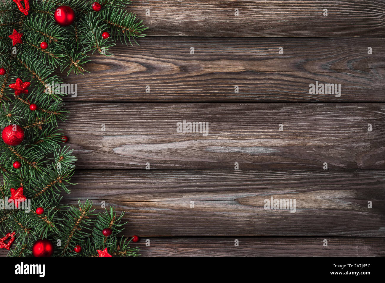 Weihnachten und Frohes Neues Jahr flach Hintergrund. Tannenzweigen mit roten Urlaub Dekorationen auf rustikalen Holztisch. Ansicht von oben mit der Kopie Raum Stockfoto