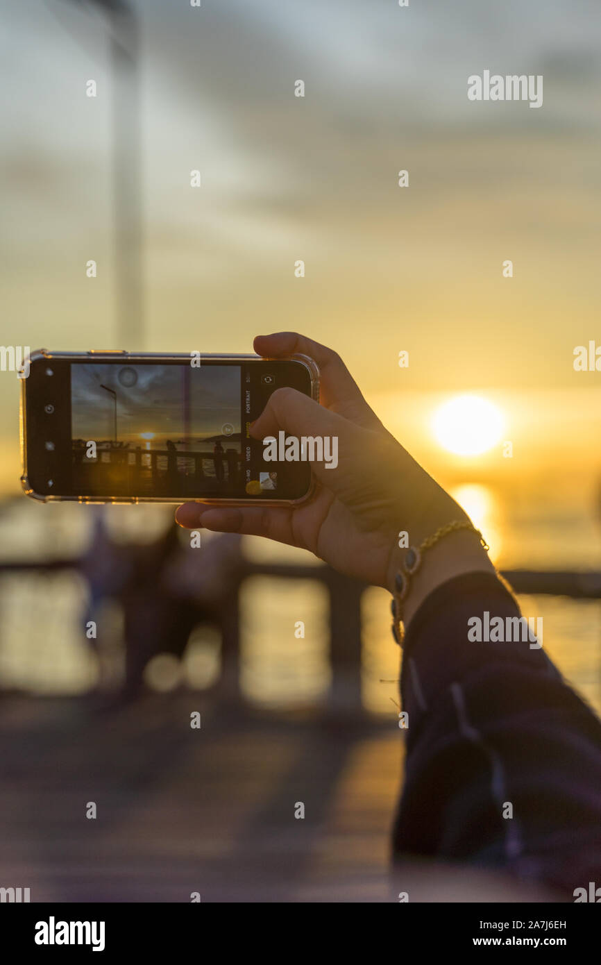 Fotografieren Sie den Sonnenuntergang mit einem Telefon Stockfoto