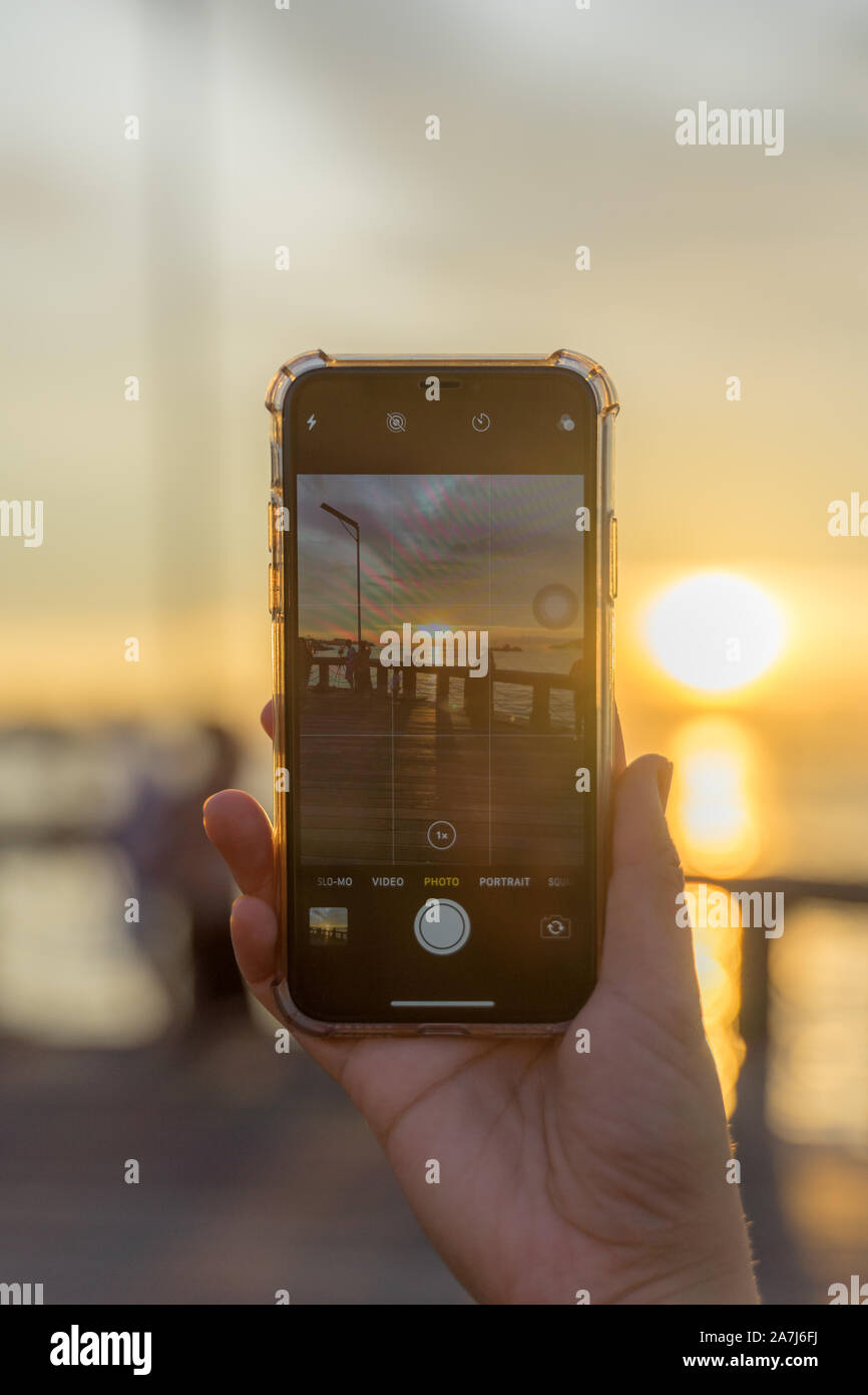 Fotografieren Sie den Sonnenuntergang mit einem Telefon Stockfoto