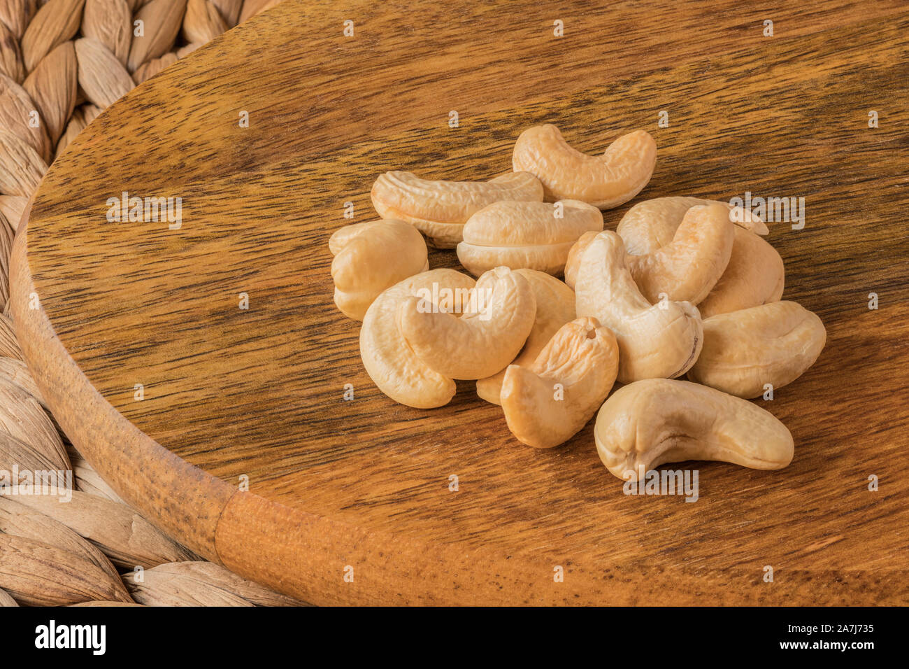 Eine Handvoll Cashewnüsse auf einer Mango Holz. Einen gesunden Snack. Stockfoto