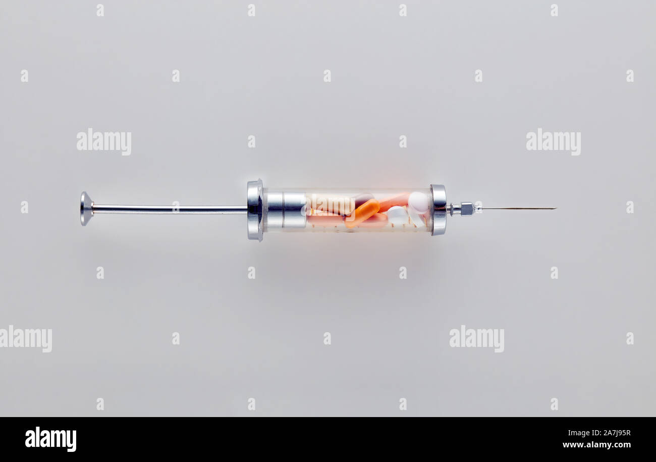 Vintage Glasspritze mit medizinische Pillen gefüllt. Konzept des Drogenmißbrauchs und der Drogenabhängigkeit Stockfoto