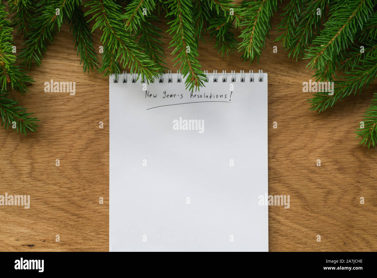 Flach neue Jahre Auflösungen notepad mit Zweigen Fichte auf Eichenholz Oberfläche gut für Hintergrund Stockfoto
