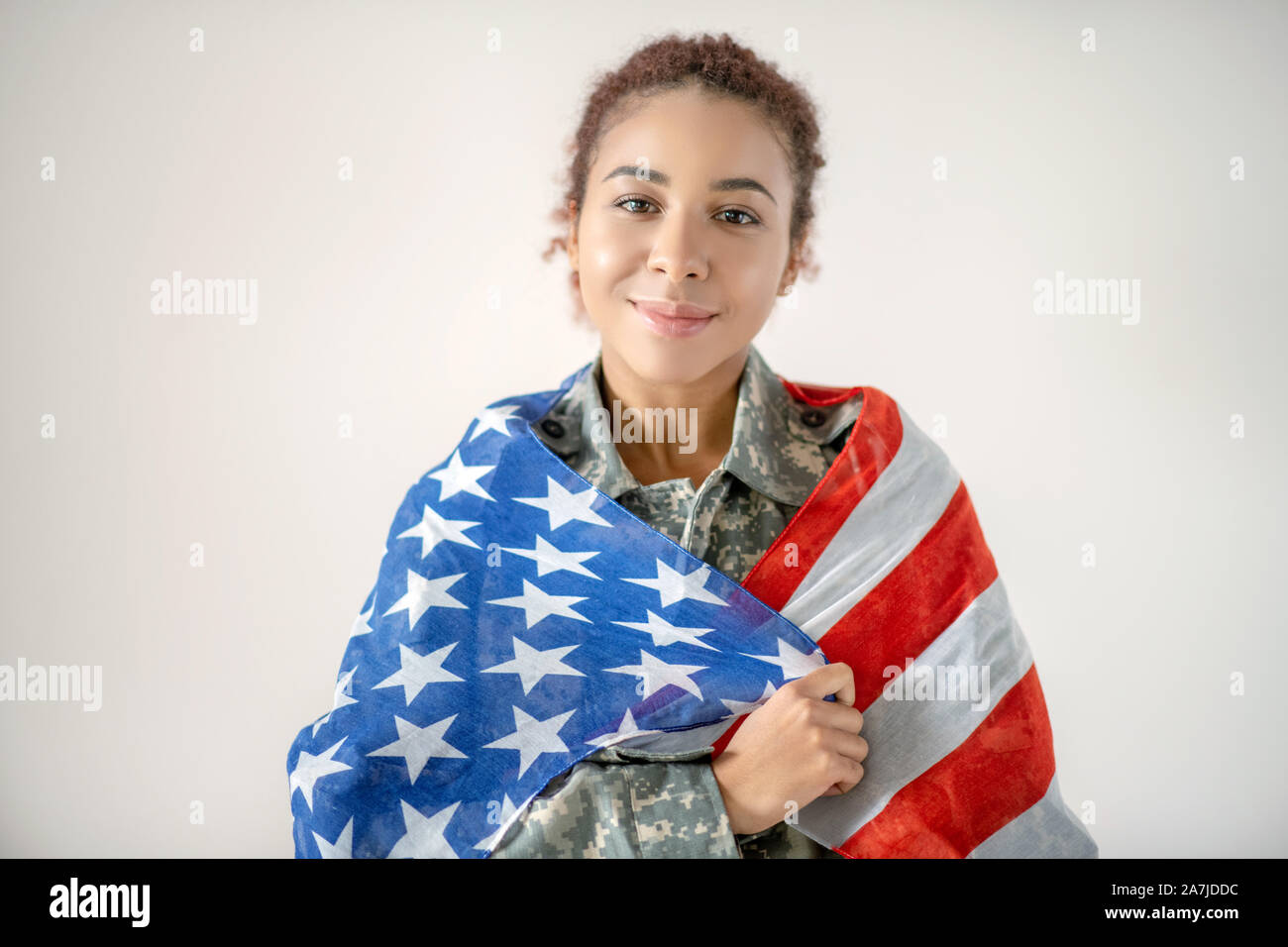 Schöne junge patriotischen servicewoman Holding amerikanische Flagge Stockfoto