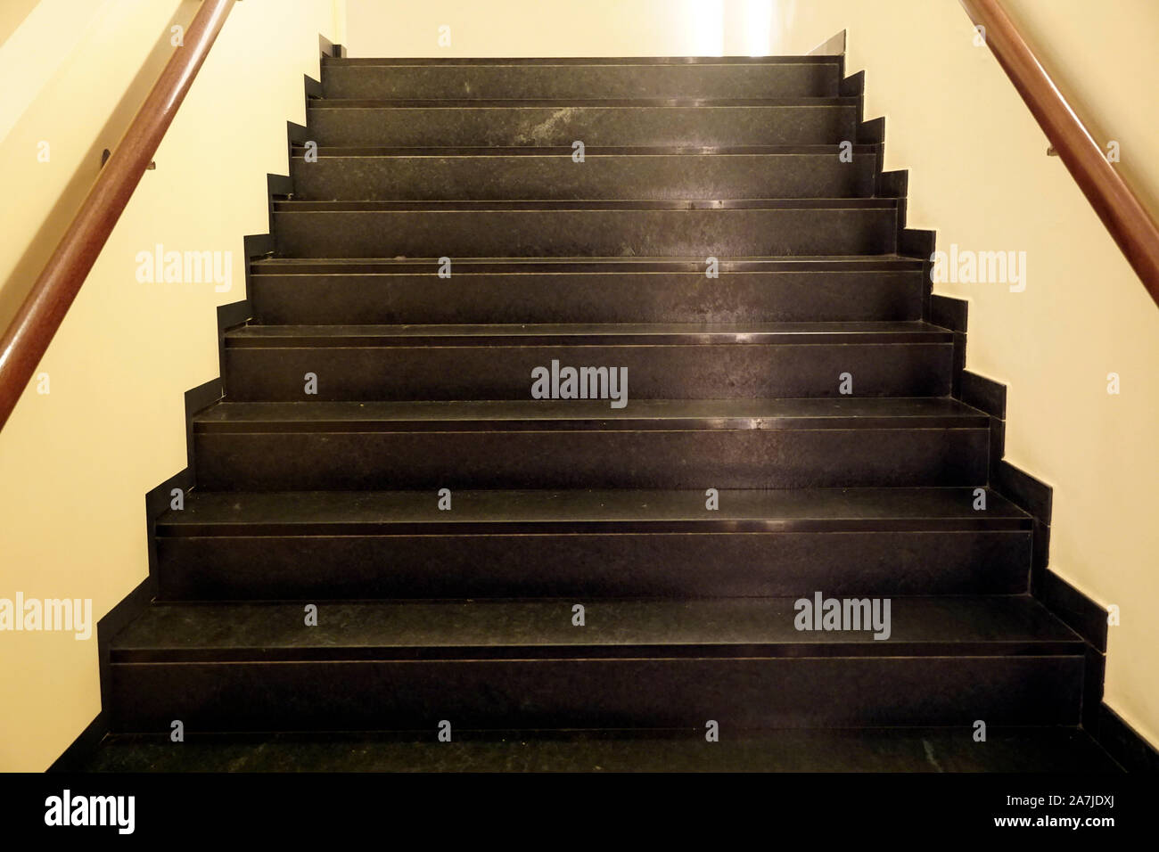 Dunkle braune Treppe mit Reflexion der Gelben Strahlen von künstlichem Licht Stockfoto