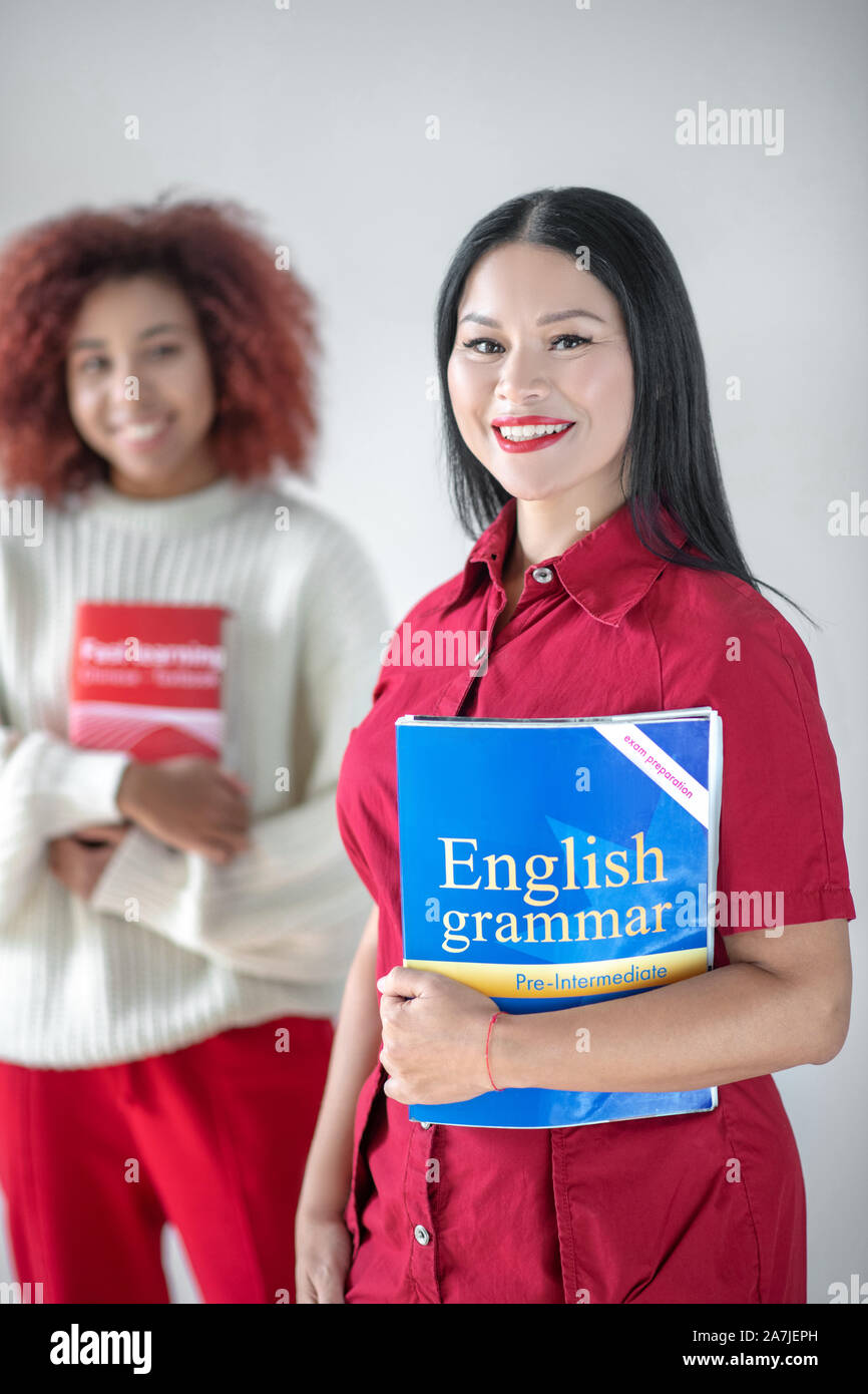 Asiatische dunkelhaarige Frau mit Englisch Grammatik Stockfoto