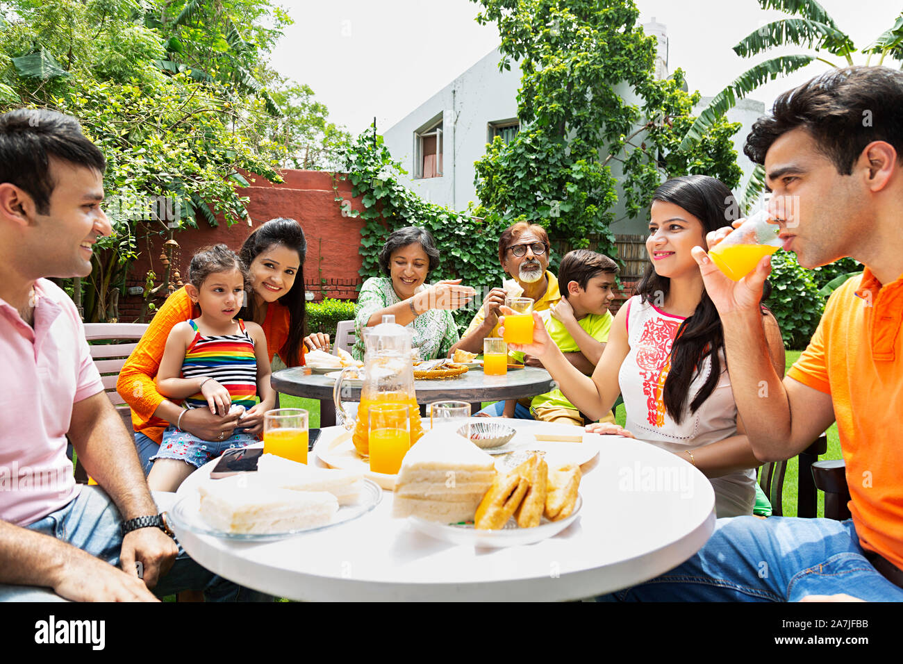 Gruppe - von großen Familien essen gesundes Frühstück zusammen im Hof ihres Hauses Stockfoto