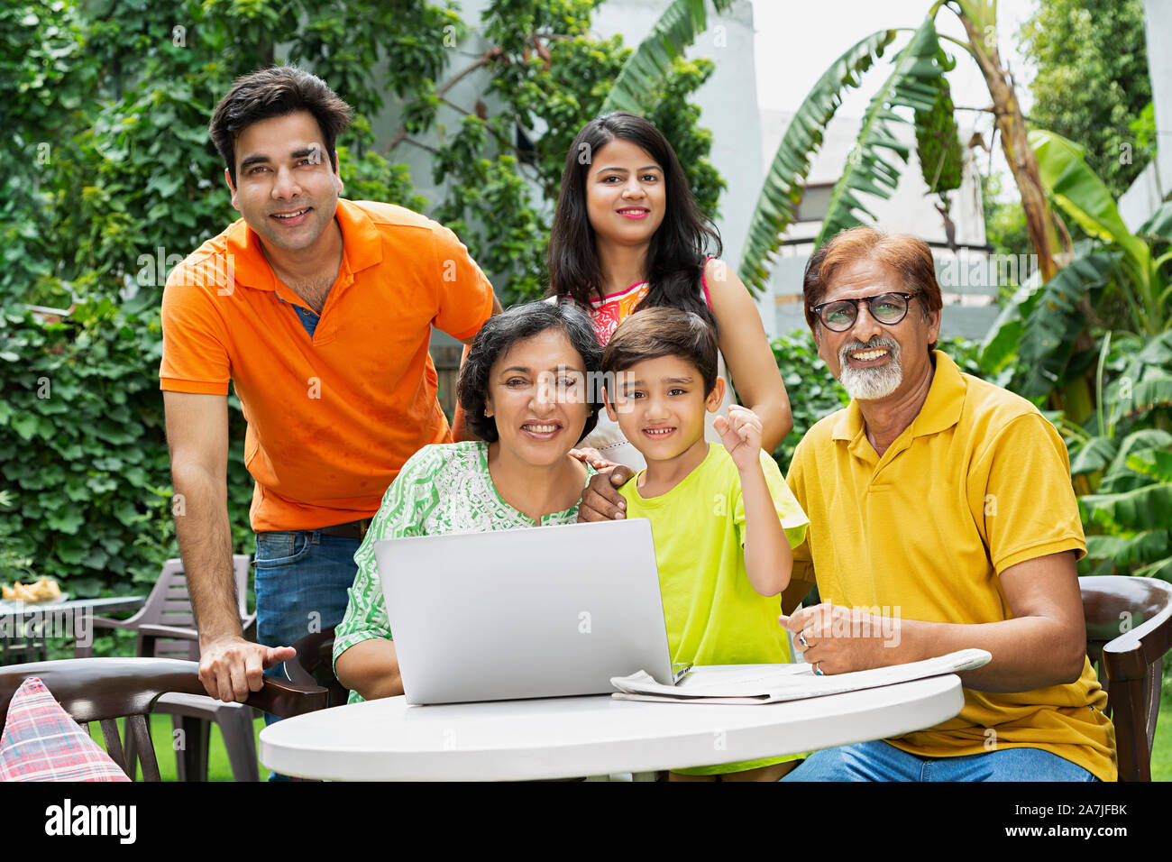 Happy Multi-Generation Familie zusammen im Hof in der Nähe von Ihrem Haus mit Laptop Hände Faust Sieg feiern. Stockfoto