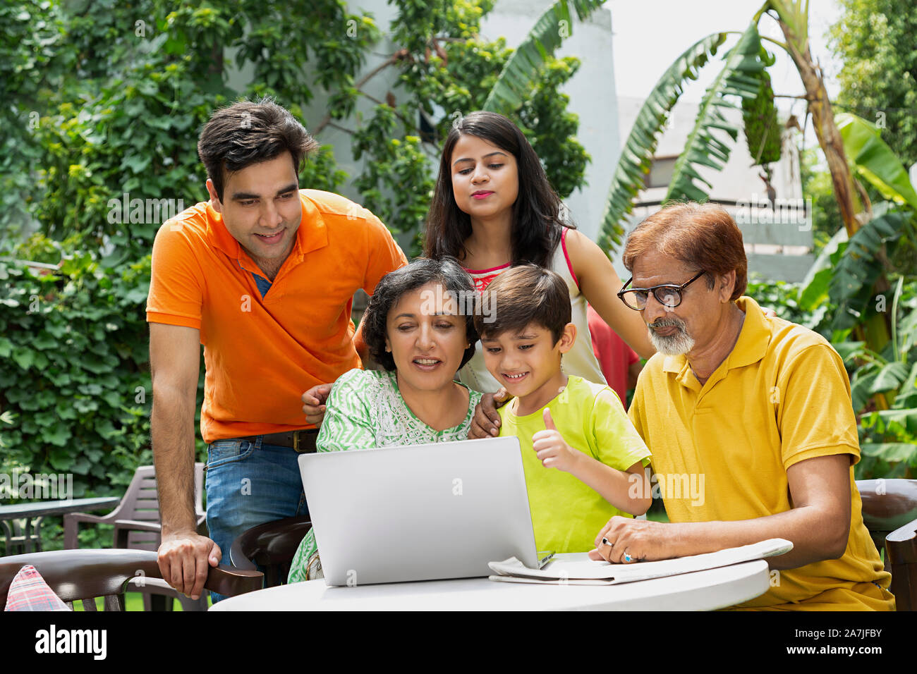 Happy Multi-Generation Familie im Innenhof zusammen tun Video auf Laptop im Garten home Chat Stockfoto