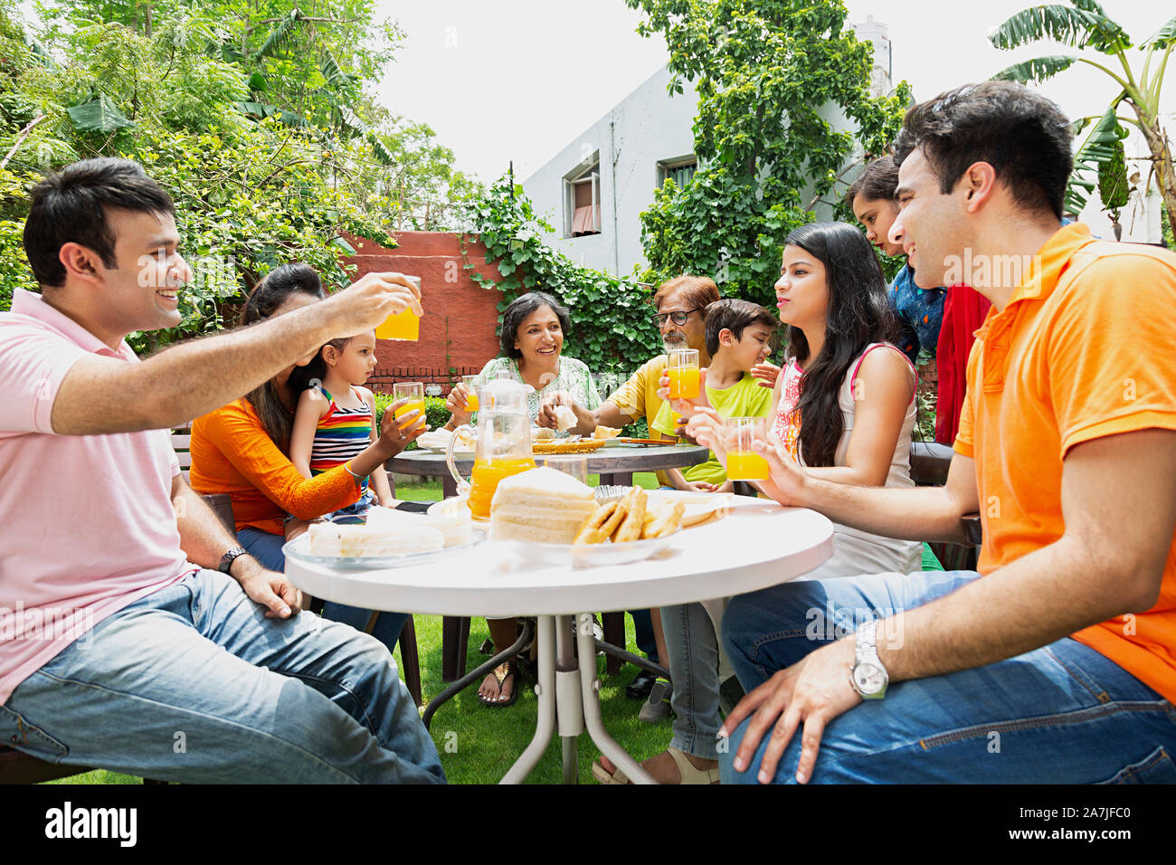 Große Gruppe von glücklichen Familien essen Frühstück zusammen im Garten Home Stockfoto