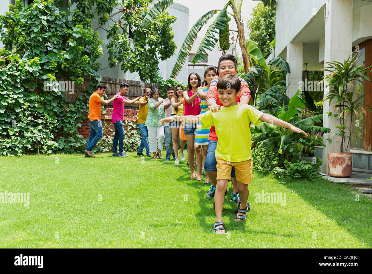 Große Gruppe von glücklichen Familien Mitglieder Gemeinsam wandern im Zug Bildung vor ihrem Haus im Garten Stockfoto