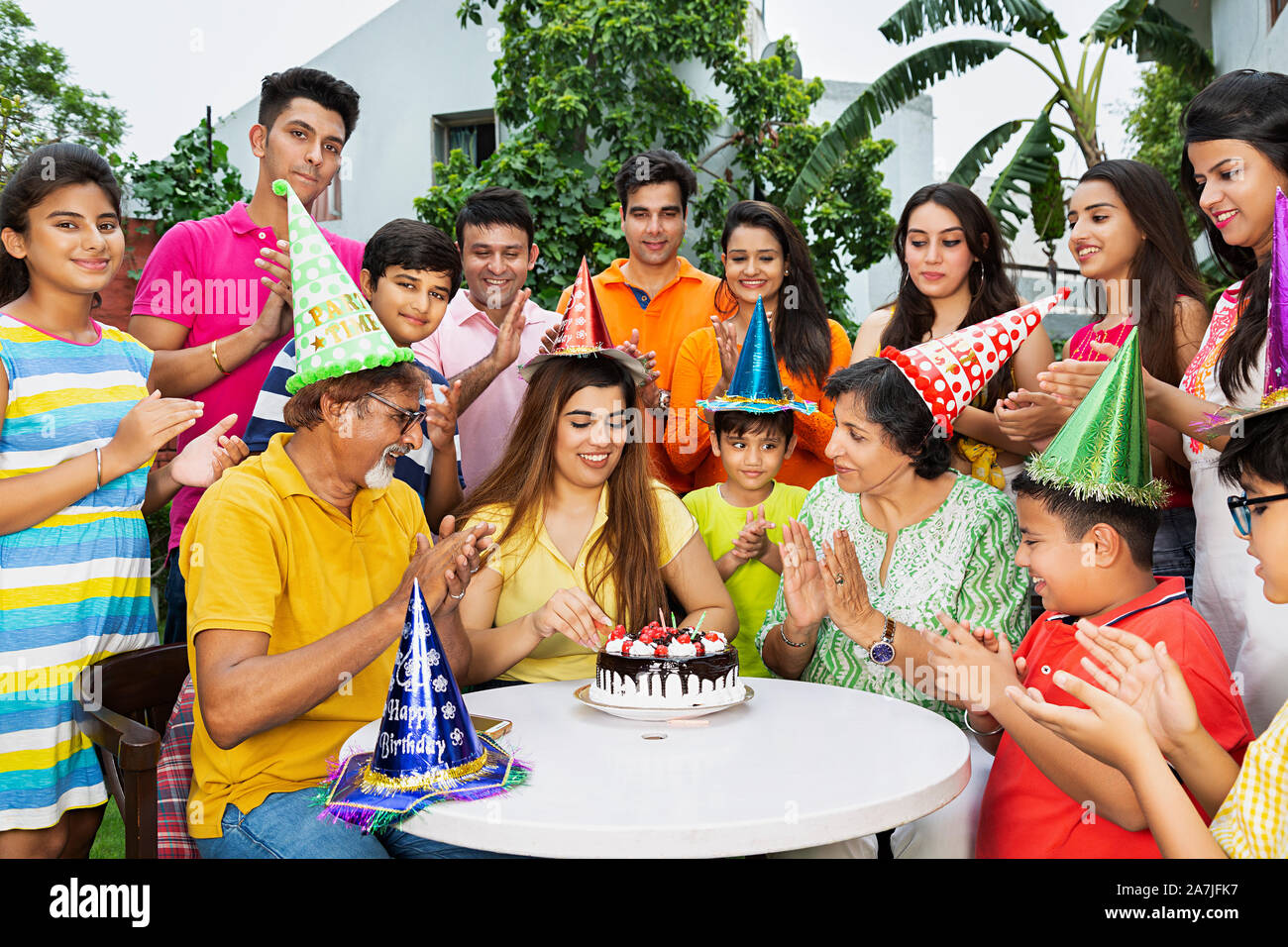 Große Gruppe - von indischen Familie Mitglieder feiern einer erwachsenen Tochter Geburtstag im Innenhof Ihres Hauses Stockfoto