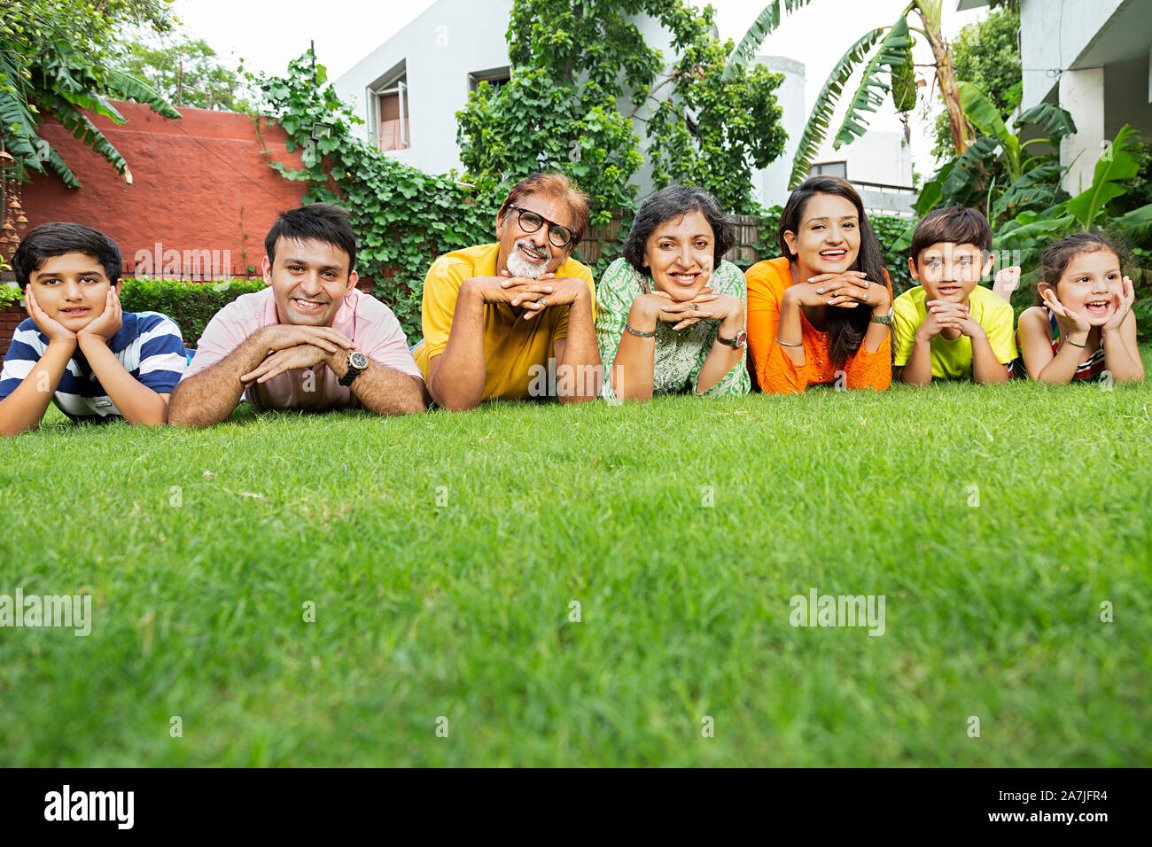 Gruppe von Happy Multi-Generation, Familie. liegend im Gras zusammen vor ihrem Haus Relaxting im Garten Stockfoto