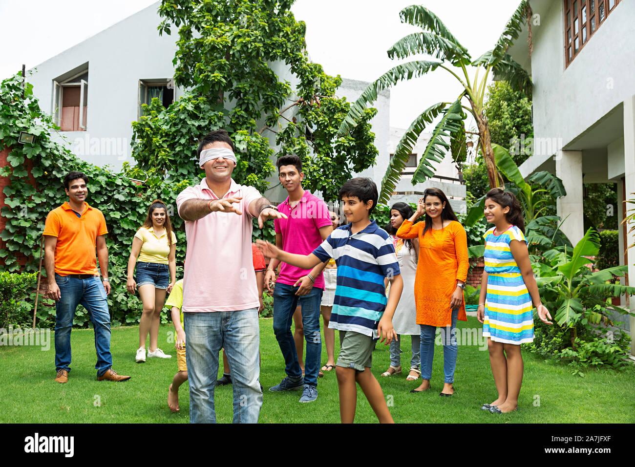 Gruppe von Happy große Familie zusammen spielen Mit Hide-und-Spiel mit verbundenen Augen Vater Spaß genießen im Garten ihres Hauses suchen Stockfoto