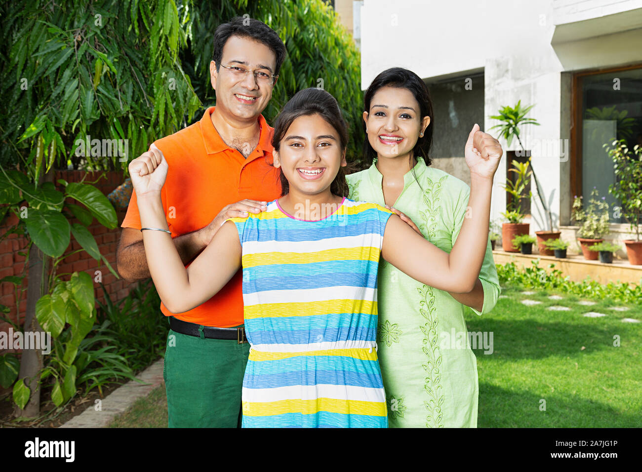 Happy-Family nach Eltern und Teenager Mädchen zusammen Fists-Hand gewinnen Erfolg feiern im Innenhof in der Nähe von Ihrem Haus Stockfoto