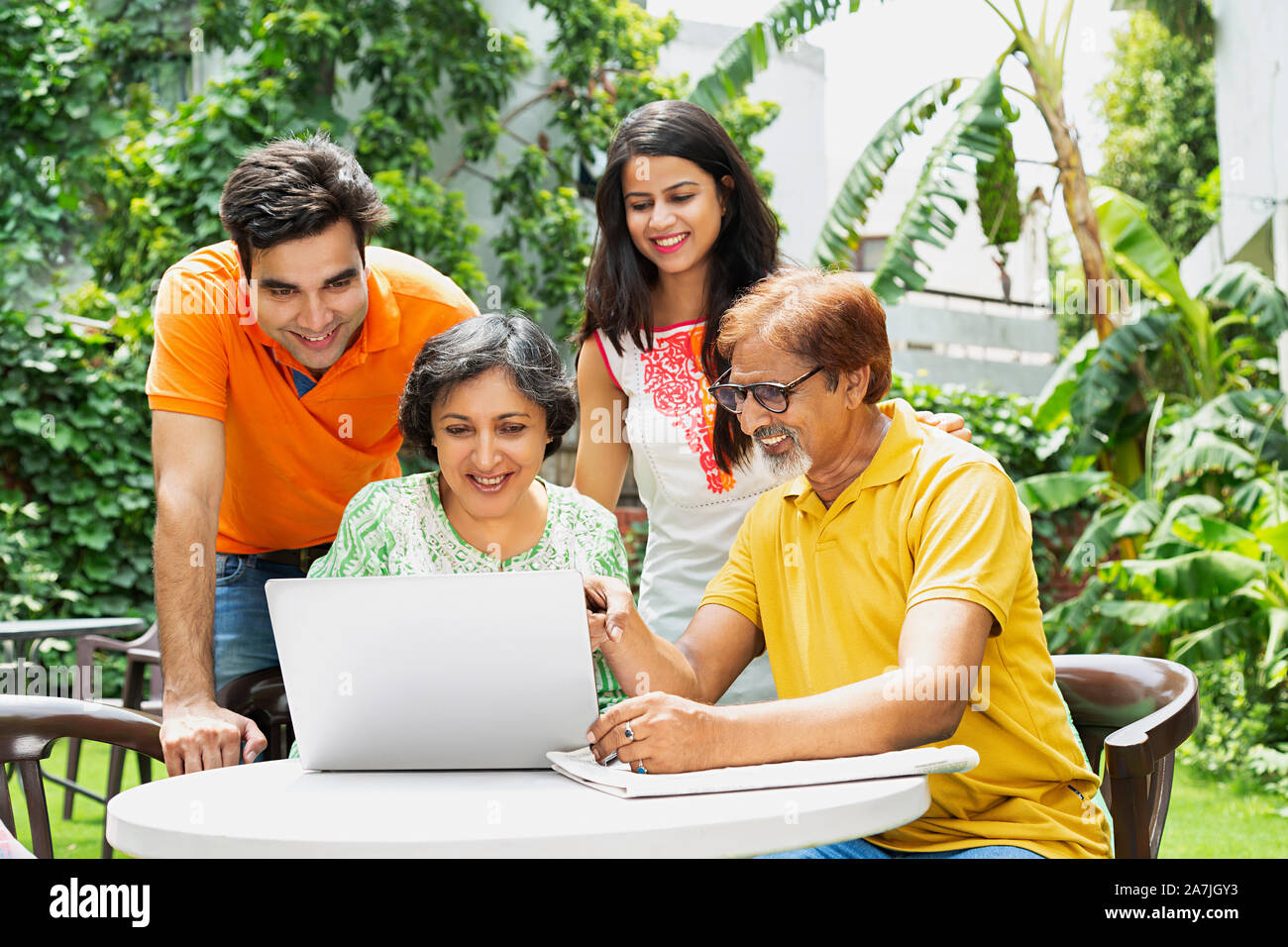 Glücklich nach Familie, Eltern und Kinder zusammen mit Laptop Chatten In-Courtyard Ihrer home Stockfoto