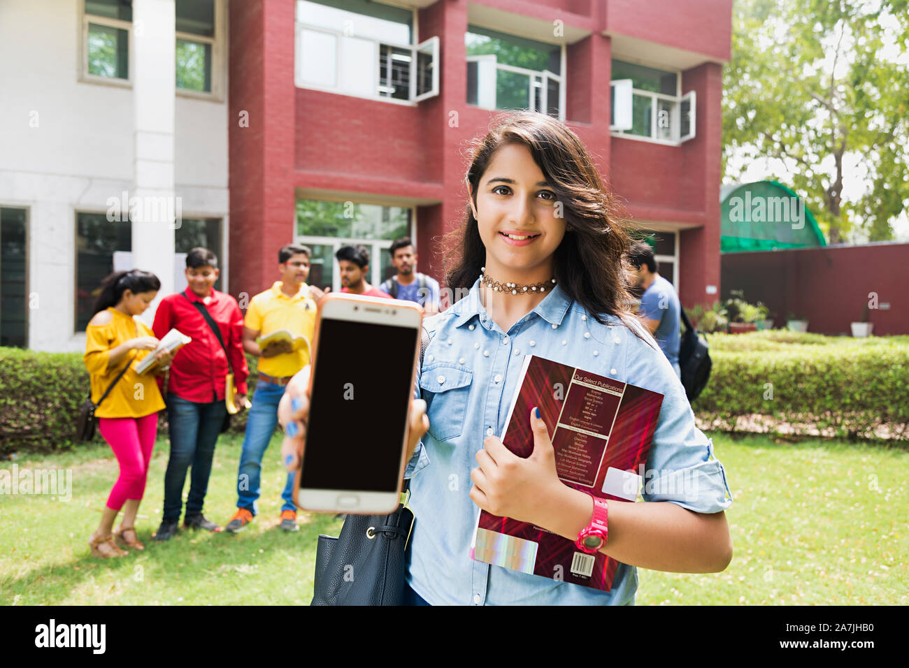 Junge Mädchen Student mit Handy Technologie Voraus und Klassenkameraden Im-ohr-Hintergrund At-Campus Stockfoto