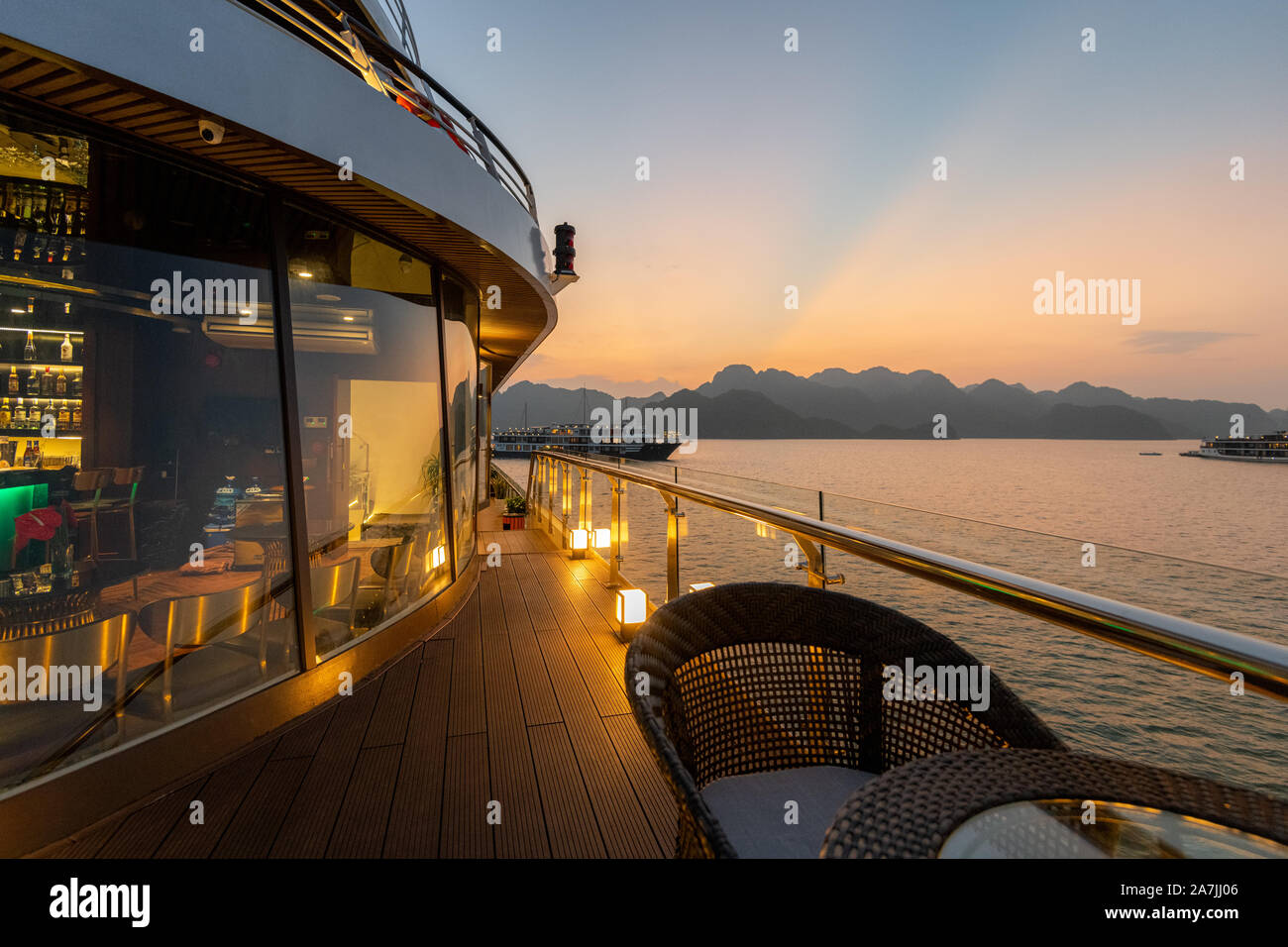 5-Sterne Luxus auf neue moderne Kreuzfahrtschiffe auf Ha Long Bay, Vietnam auf der Suche über den atemberaubenden Kalkfelsen bei Sonnenuntergang Stockfoto