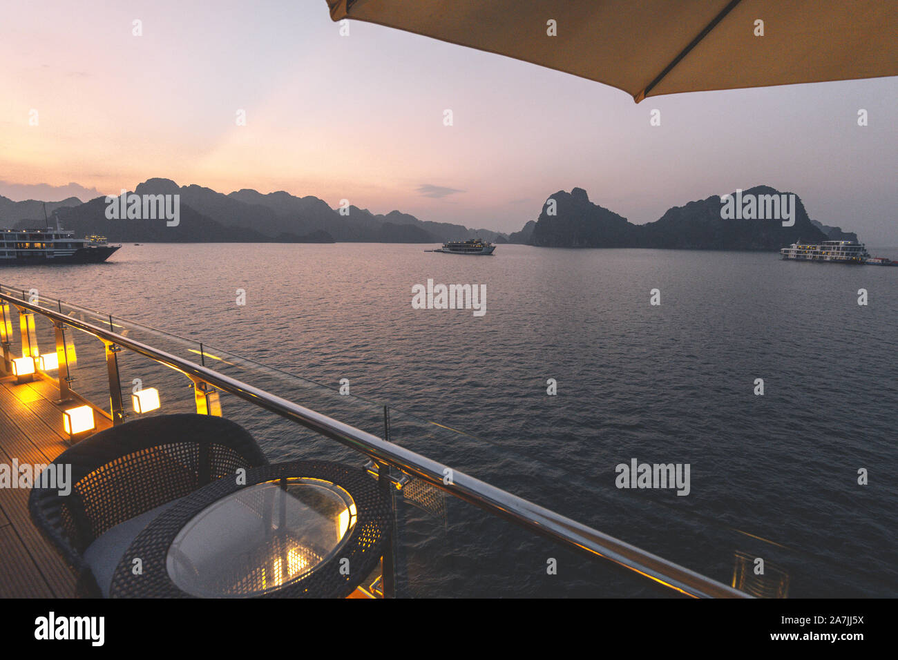 5-Sterne Luxus auf neue moderne Kreuzfahrtschiffe auf Ha Long Bay, Vietnam auf der Suche über den atemberaubenden Kalkfelsen bei Sonnenuntergang Stockfoto