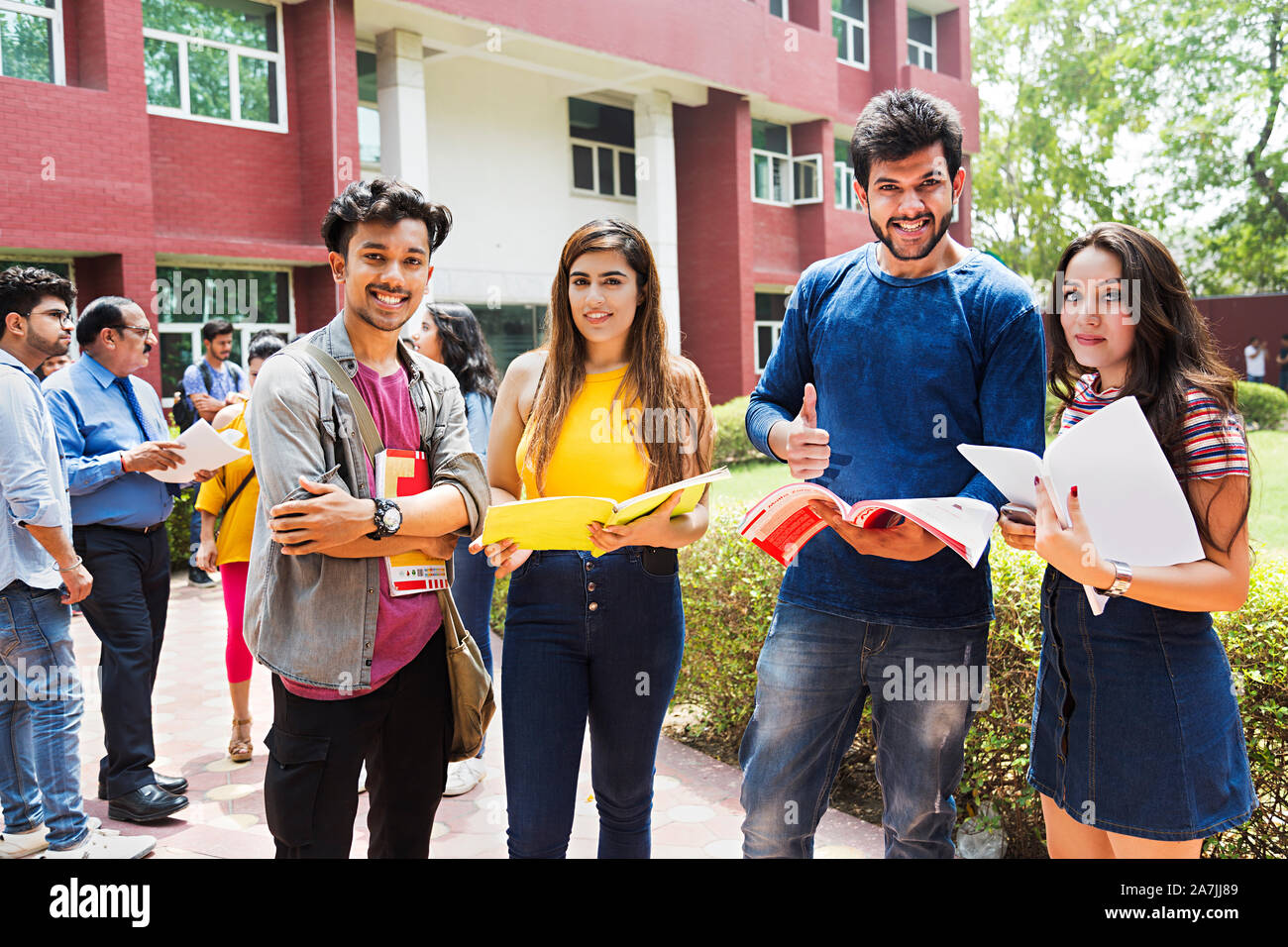 Vier College Mädchen und Jungen Studenten Freunde Studium Buch angezeigt Thumbs-up mit At-Campus People-In - Hintergrund Stockfoto