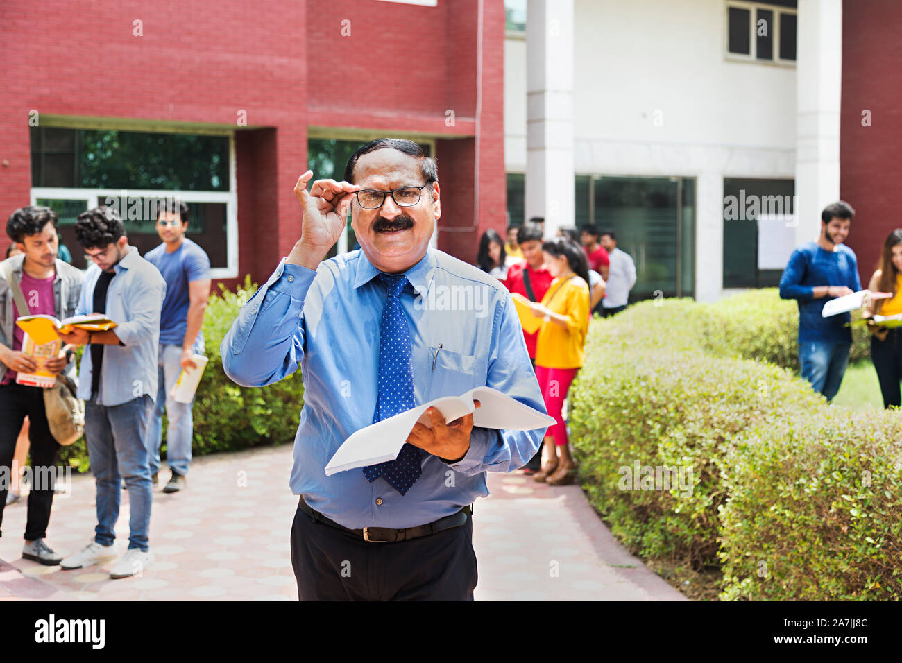 Indische Hochschullehrer Buch mit Studenten Im-ohr-Hintergrund In-Outside Campus Gebäude Stockfoto