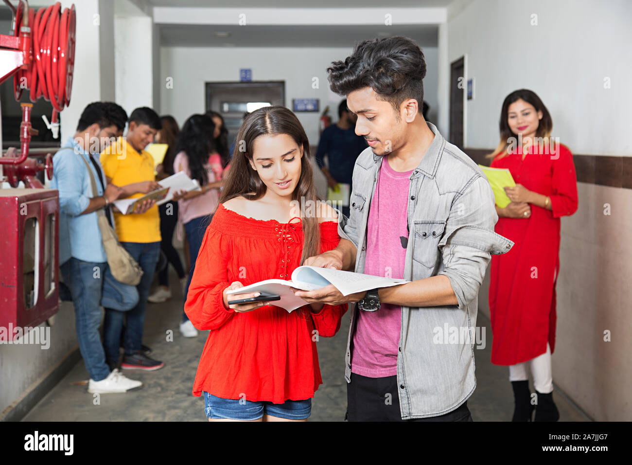 Zwei College Junge und Mädchen Schüler Freunde Buch zusammen mit In-Corridor At-Campus Students-In - Hintergrund Stockfoto