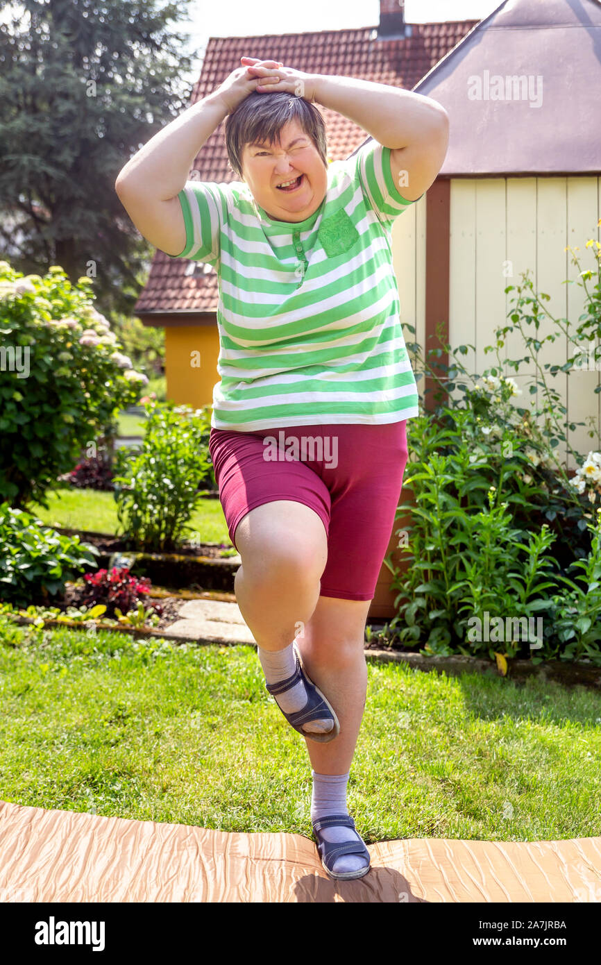 Geistig behinderte Frau ist dabei einige unterstützte Übungen für Ihre Fitness Stockfoto