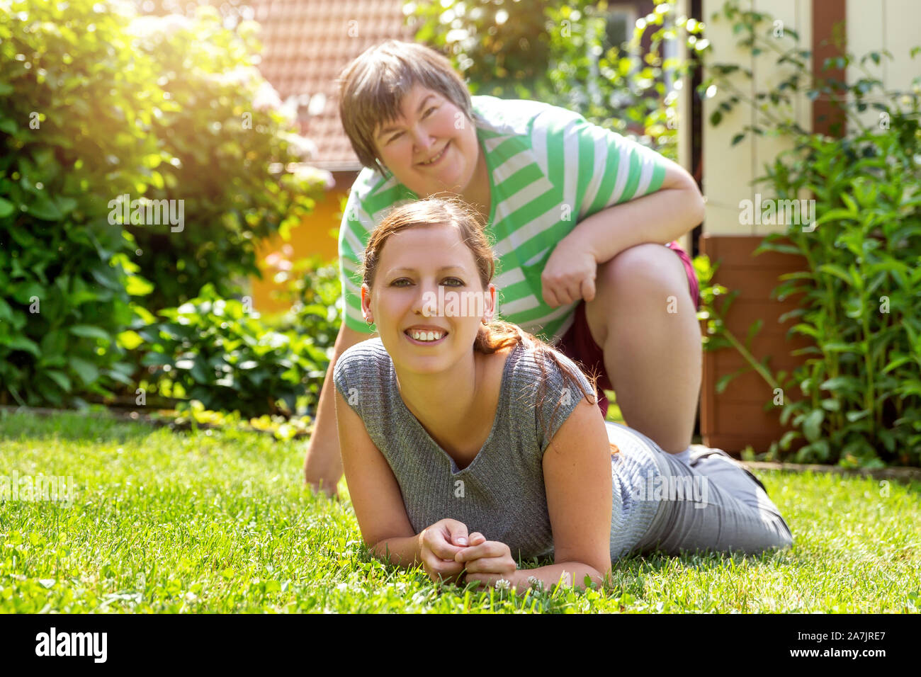 Lächelnd geistig behinderte Frau und einem Freund im Garten, sonnigem Wetter Stockfoto