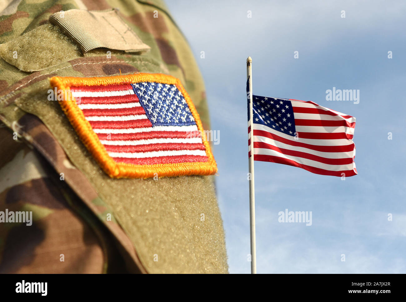 Veterans Day. US-Soldat. US-Armee. Militär der USA. US Army uniform Aufnäher Fahne und Flagge der USA das Weben in den Himmel. Stockfoto