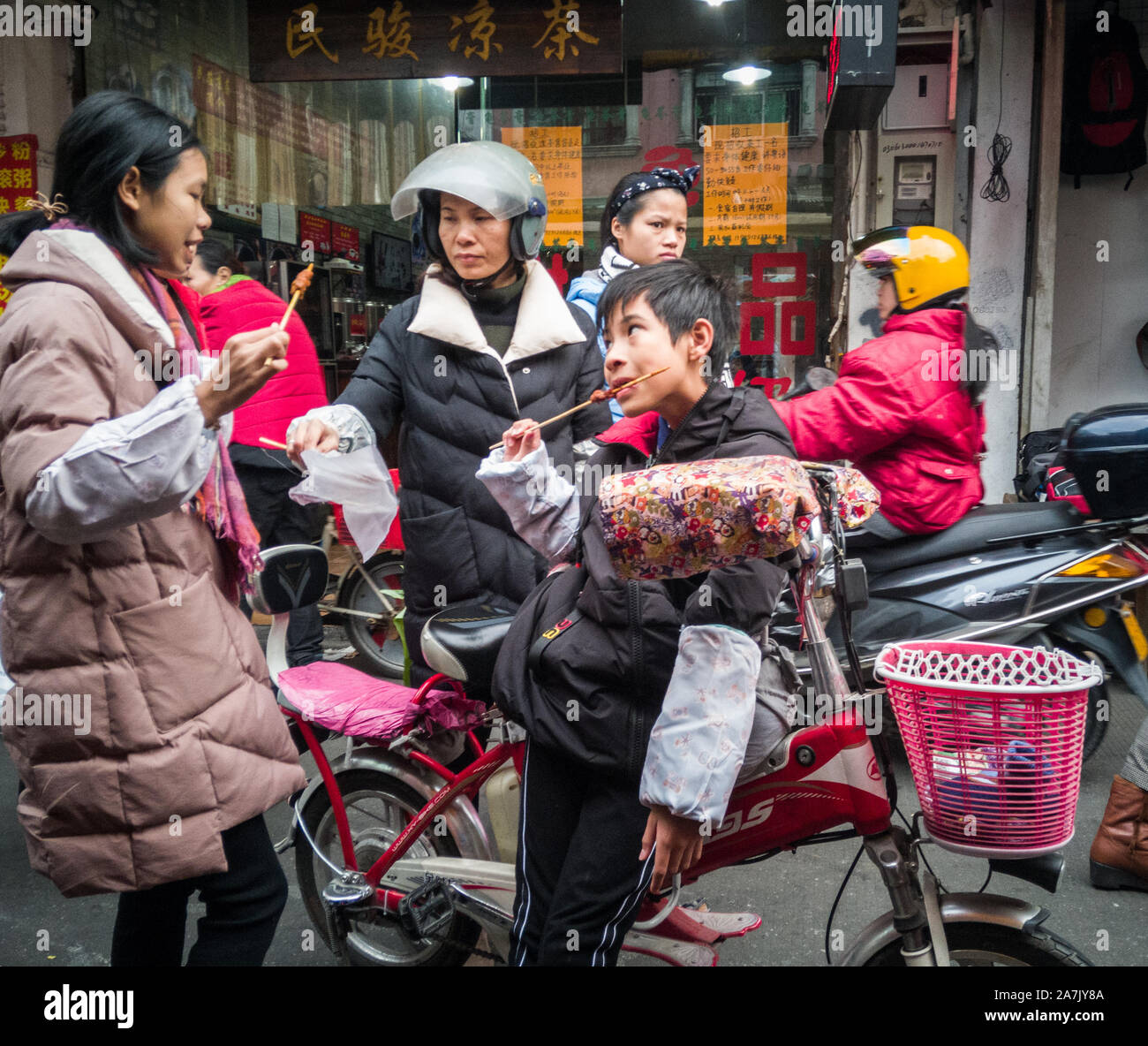 2019.01.01 - ein Junge war Essen Gegrilltes mit seiner Familie auf der Straße. Stockfoto