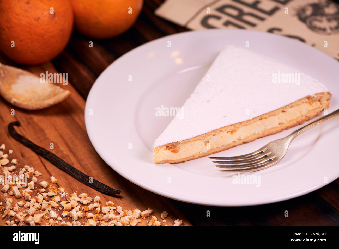 Teil der hausgemachten italienischen Ricotta Käsekuchen mit gehackten kandierten Orangenschalen und bestreut mit Puderzucker auf Holz- Hintergrund. Italienische recip Stockfoto