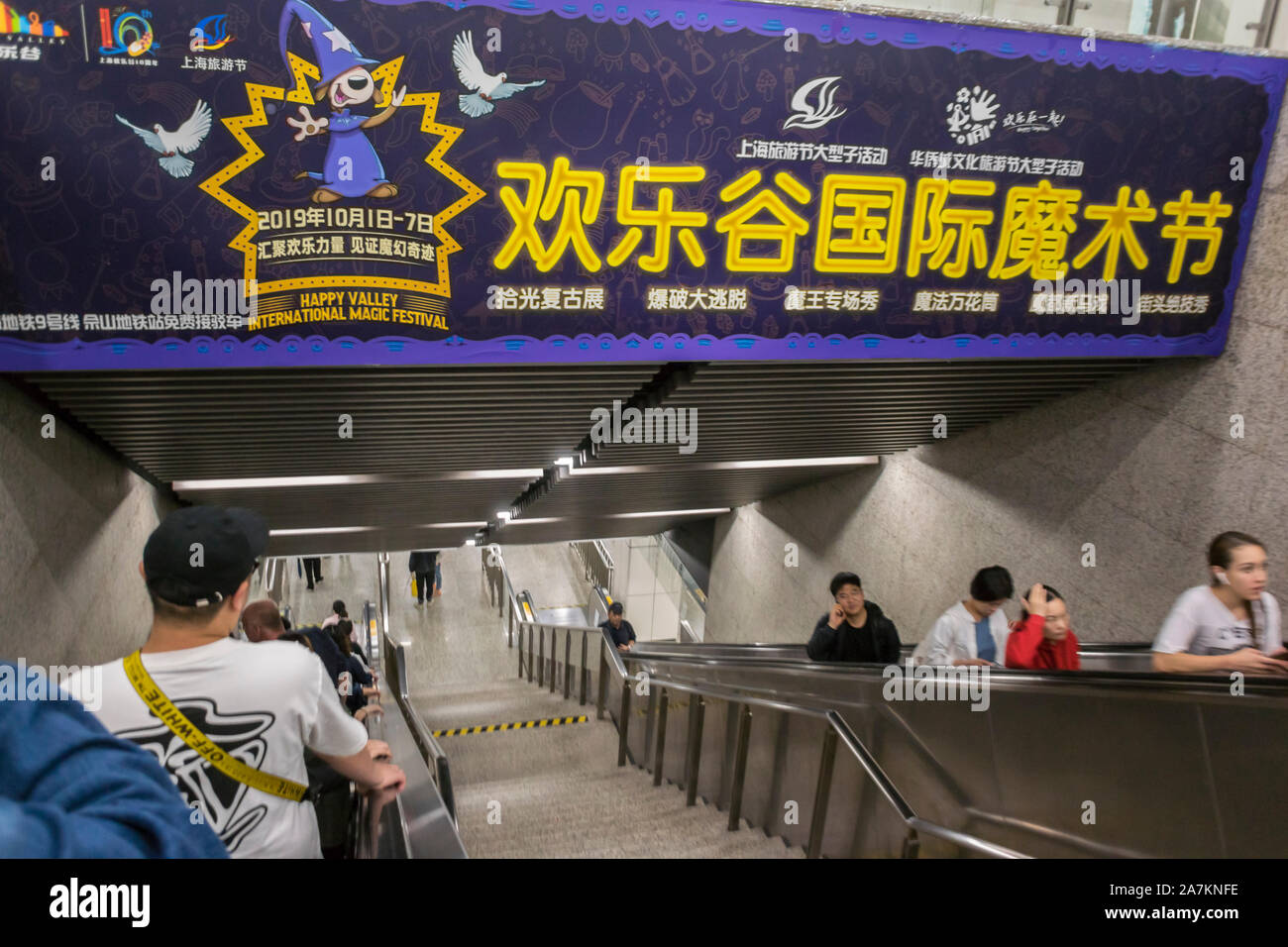 Shanghai, China, Menschenmassen, die die chinesische U-Bahn-Station nutzen, Inside, Werbetoster, Reiseplakate, unterirdische U-Bahntreppe Chinesischer Vergnügungspark « Happy Valley International Magic Festival » shanghai Metro Stockfoto