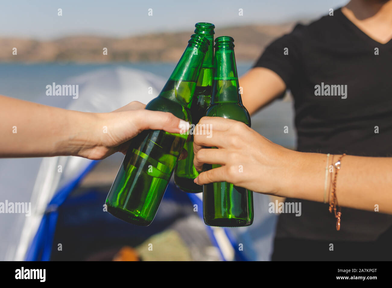In der Nähe der Hände Bier Holding und Jubel gegen camping Zelt am Strand. Stockfoto