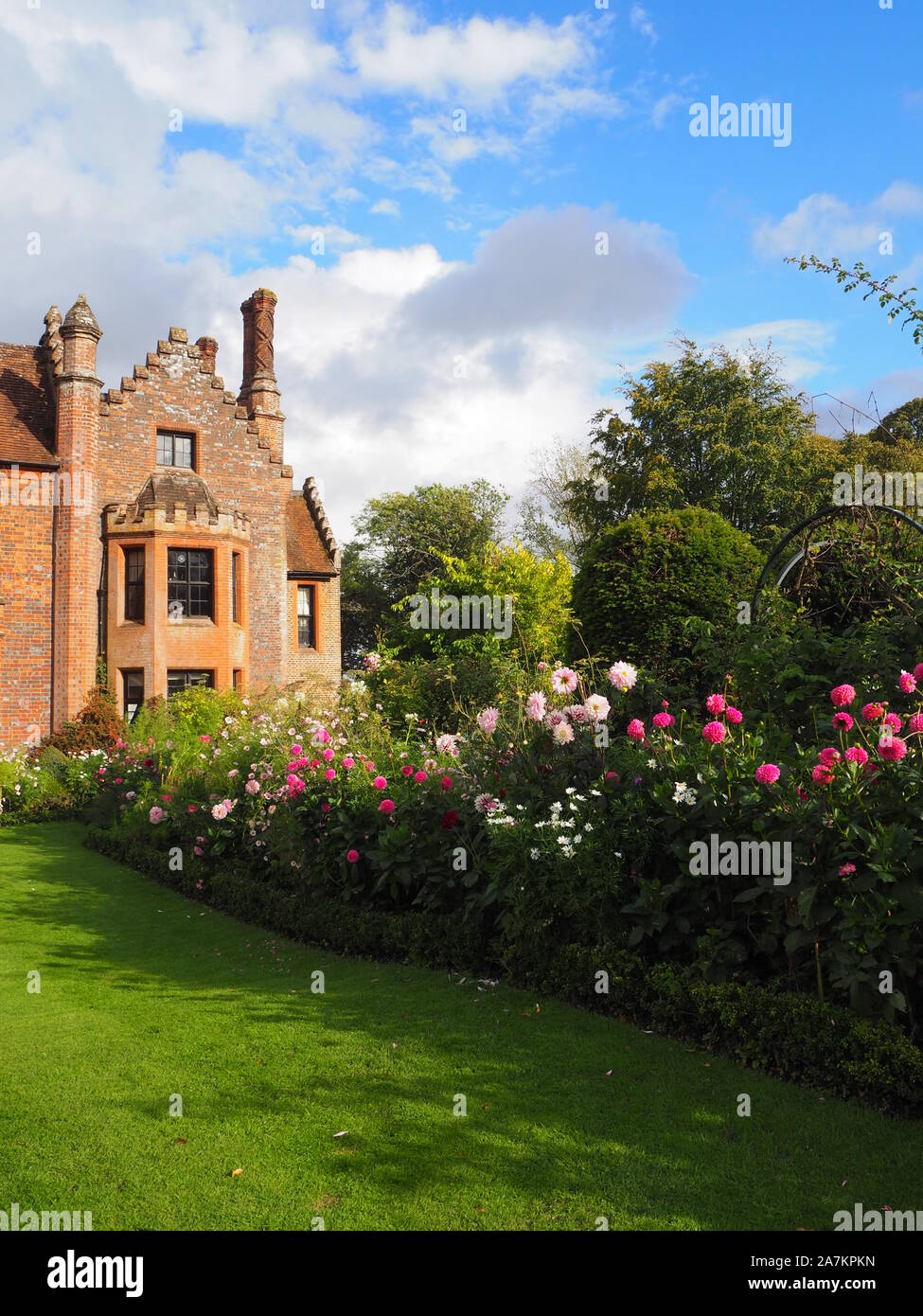 Chenies Manor House mit Blick auf South West, die durch die Grenzen mit bunten Pink Dahlia Sorten und Kosmos auf eine feine September Abend umrahmt. Stockfoto