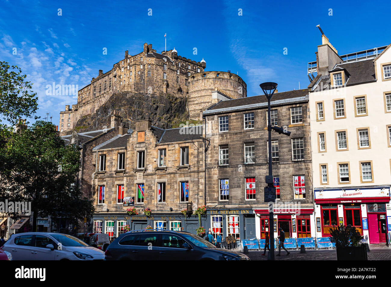 Blick auf die Burg von Edinburgh über historische Gebäude in der Grassmarket mit blauem Himmel. Edinburgh, Schottland. Stockfoto
