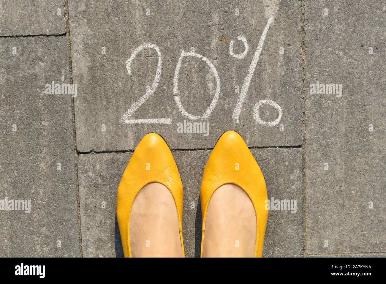 Text 20 Prozent auf grauem Pflaster mit Frau Beine geschrieben, Ansicht von  oben Stockfotografie - Alamy