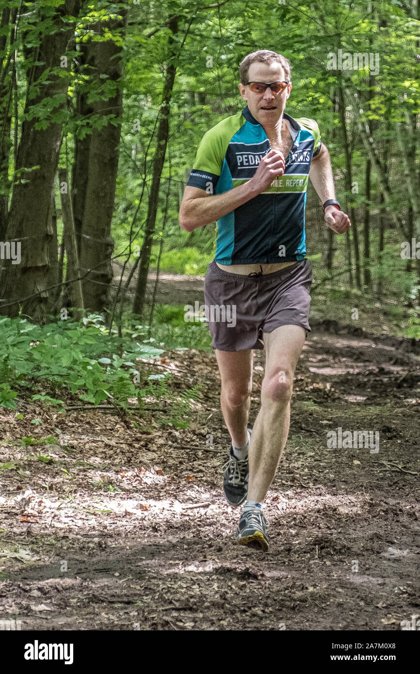 Leute, die in einem Rennen auf einem Waldweg Stockfoto