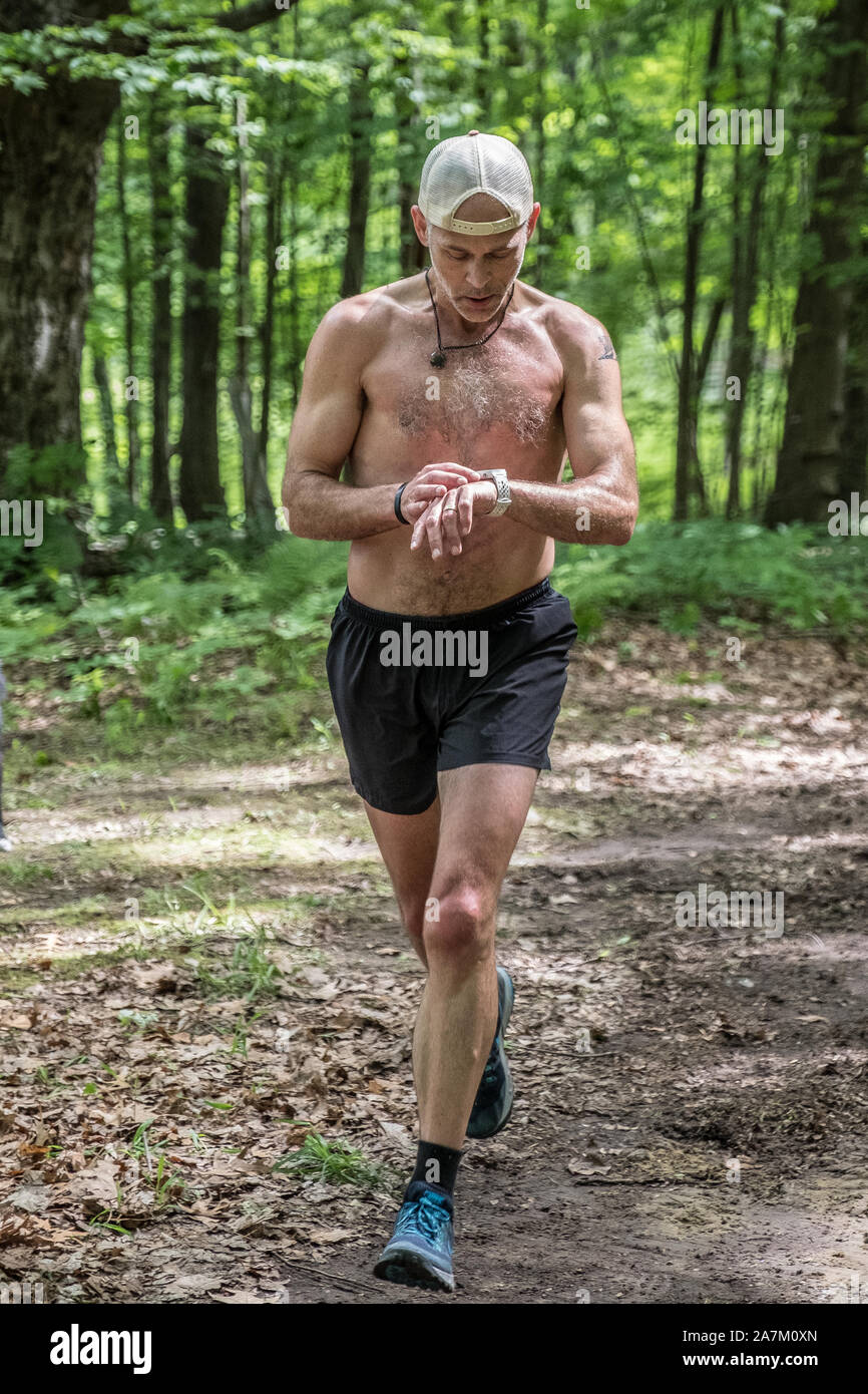 Leute, die in einem Rennen auf einem Waldweg Stockfoto