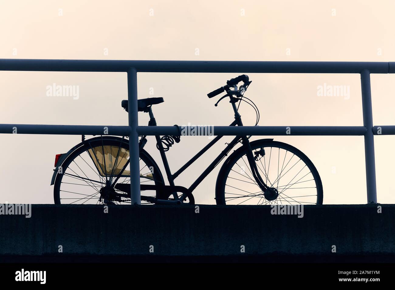 Fahrrad auf einer Straße Silhouette gegen Dämmerung Himmel Stockfoto