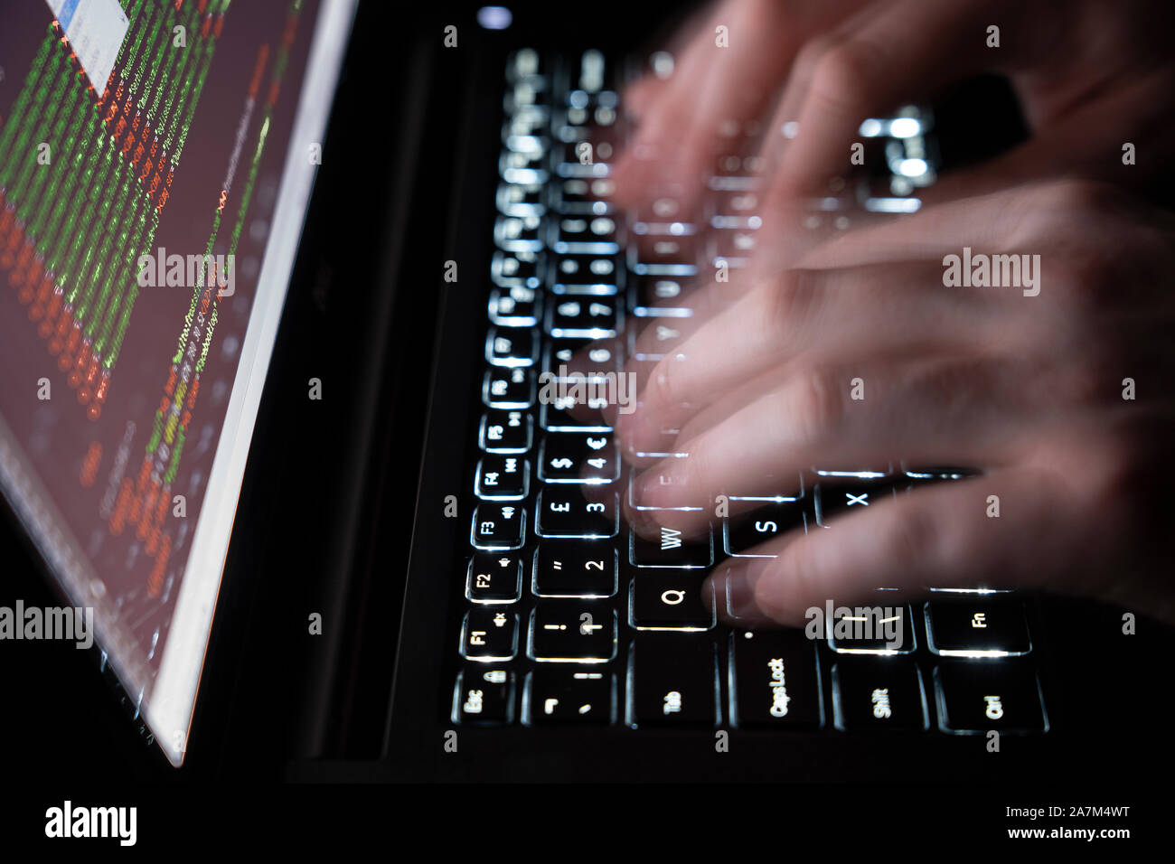 Bewegliche Hände schreiben auf Tastatur eines Computers - Begriff der Cybersicherheit, Phishing, Hacking, social engineering Angriff, dunkle Web, Viren und Trojaner Stockfoto