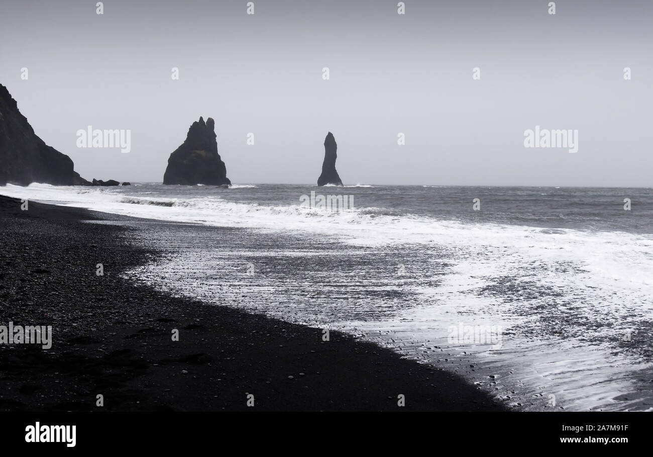 Dramatische Landschaft mit schwarzem Sand Strand Reynisfjara in Island an einem bewölkten Tag Stockfoto