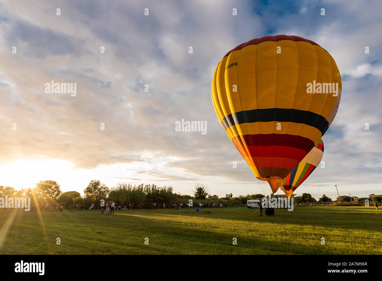 Paestum, Italien, September 2019 Balloon Festival, Heißluftballon in ein grünes Feld bei Sonnenuntergang Stockfoto