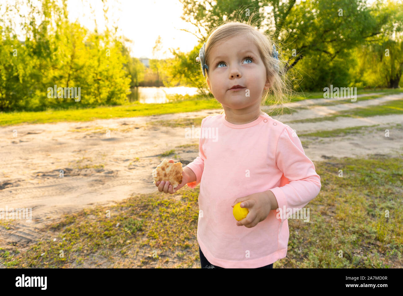 Kleines Mädchen mit lustigen emotionale Gesicht mit Brot in Händen Stockfoto
