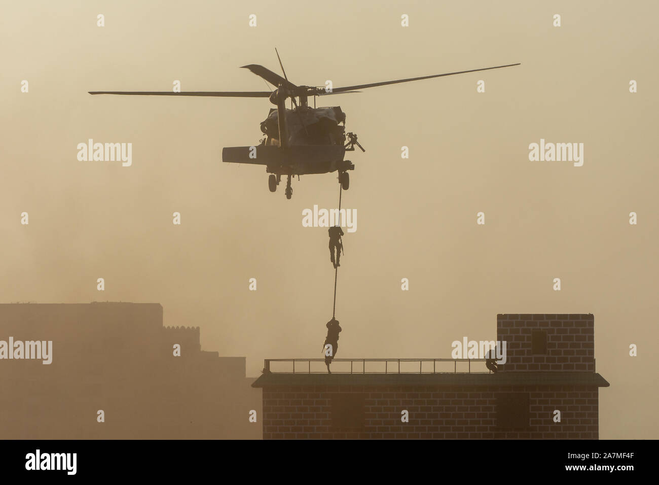 Militärischen Kampf und Krieg mit dem Hubschrauber in das Chaos und Zerstörung zu fliegen. Soldaten aus Seil auf den Boden von Chopper aussetzen. Militärisches Konzept Stockfoto